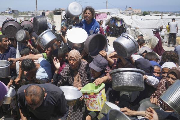 Palestinos a morrer de fome lutam para receber alimentos em Khan Younis, Faixa de Gaza, 23 de maio de 2025